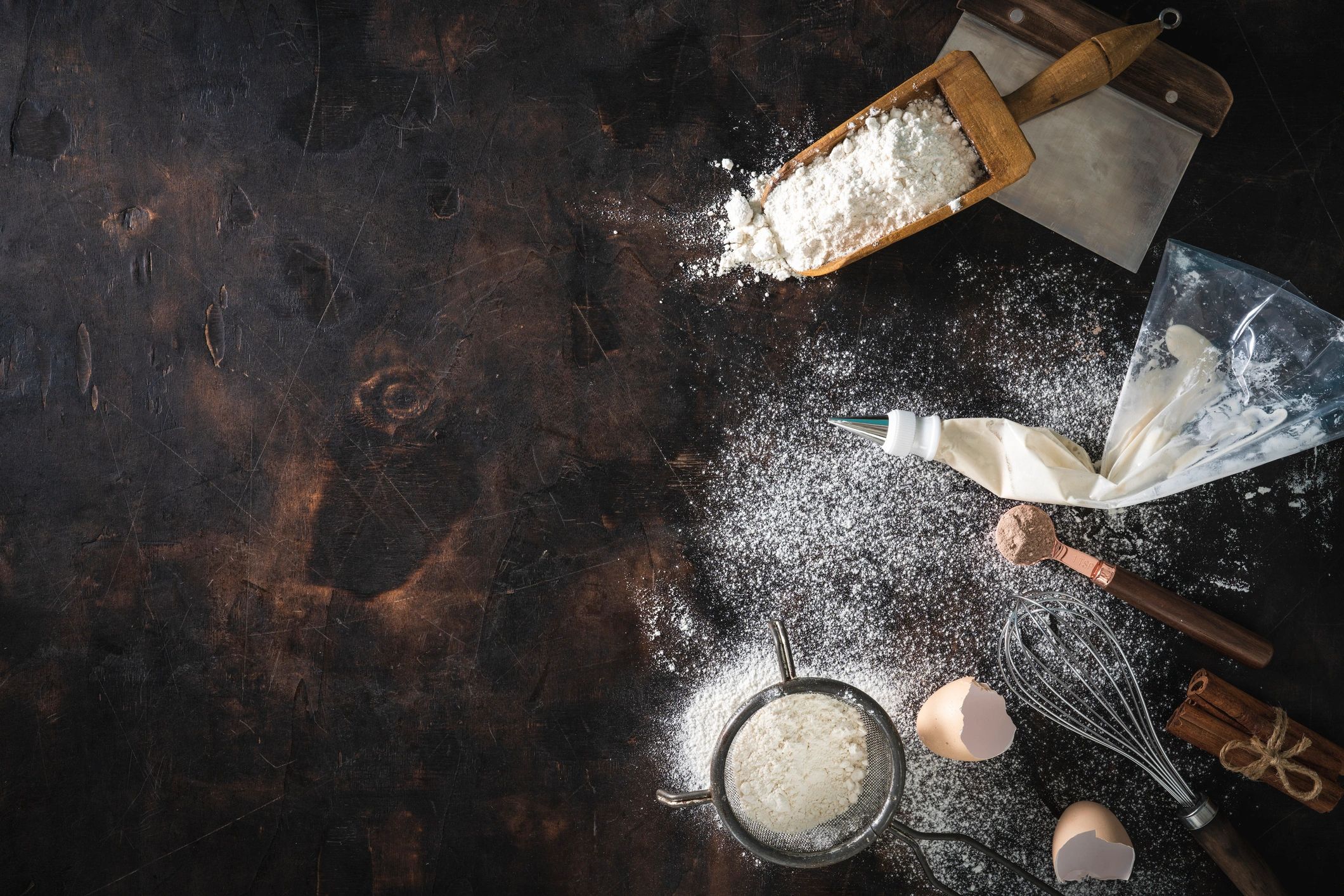 Ingredientes y utensilios de repostería sobre mesa oscura